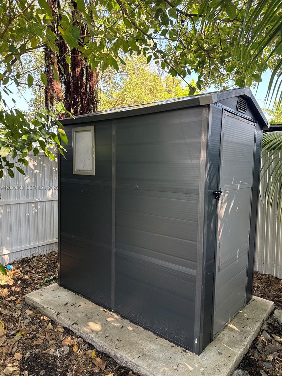 A dark gray storage shed sits on a concrete slab in a backyard — 2730 NW 44th Steet # 3, Miami FL 33142, MIAMI, FL
