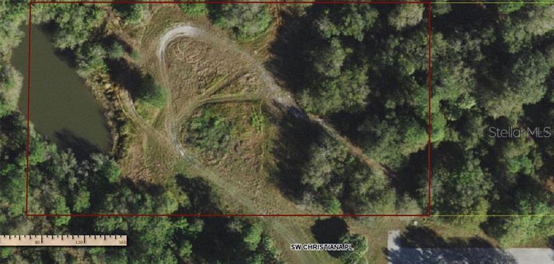 An aerial view shows a rectangular plot of land featuring a pond and dirt paths — 11972 SW CHRISTIANA PLACE, ARCADIA, FL