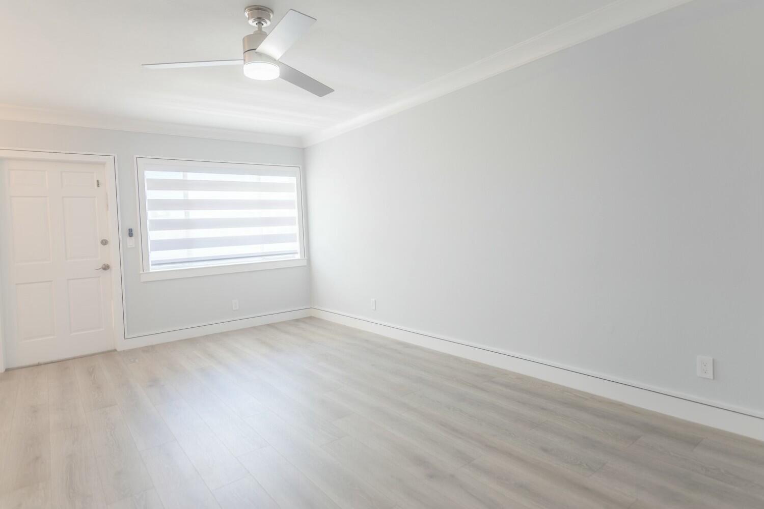 An empty room with light gray walls, wood-look flooring, a ceiling fan, and a window — 2840 Cynthia 204 Lane # 204, FL 33461, FL