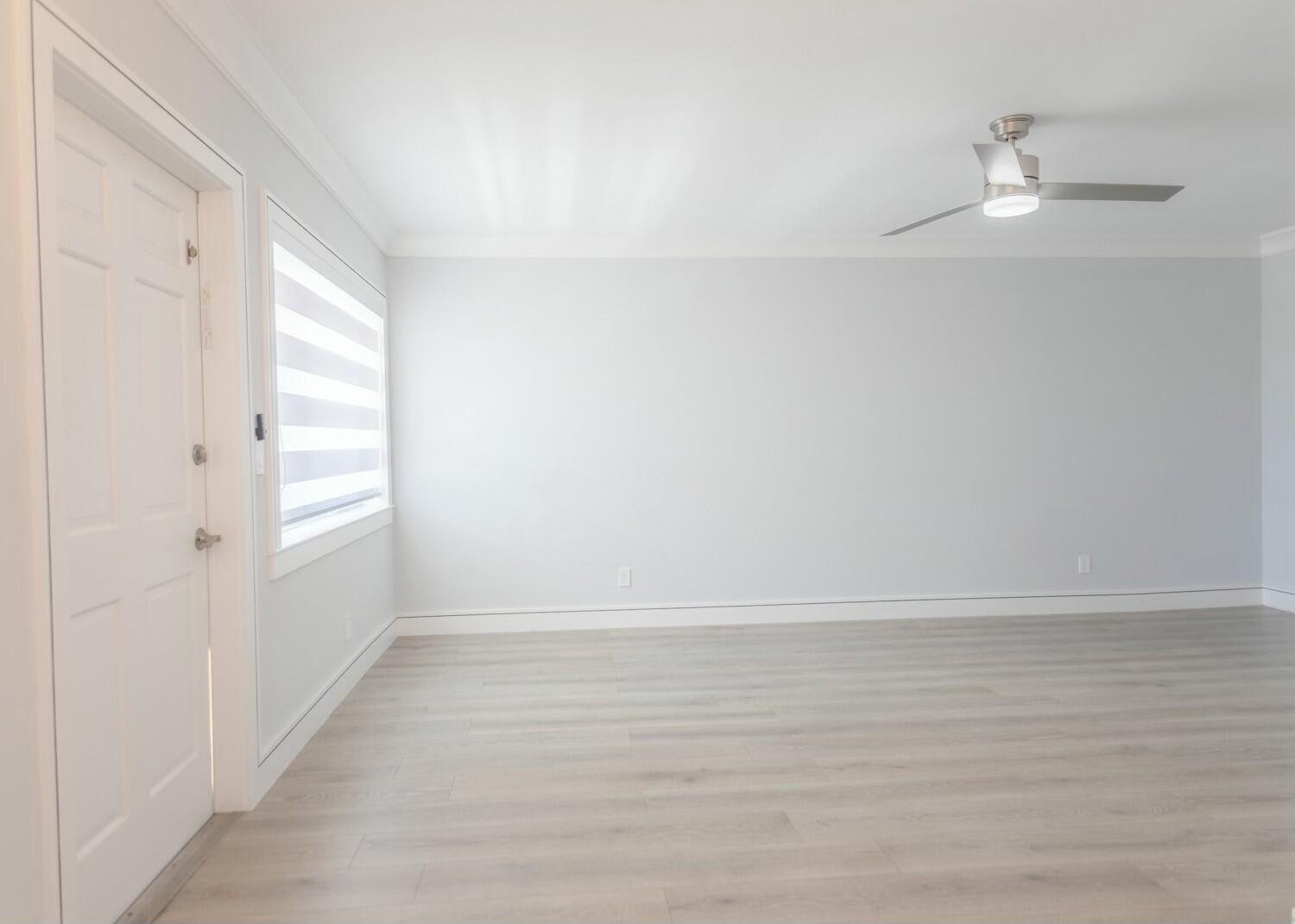 An empty room with light gray walls, wood-look flooring, a ceiling fan, and a window — 2840 Cynthia 204 Lane # 204, FL 33461, FL