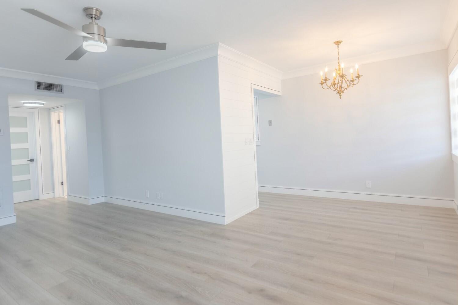 An empty room with light wood-look flooring, a ceiling fan, and a brass chandelier — 2840 Cynthia 204 Lane # 204, FL 33461, FL