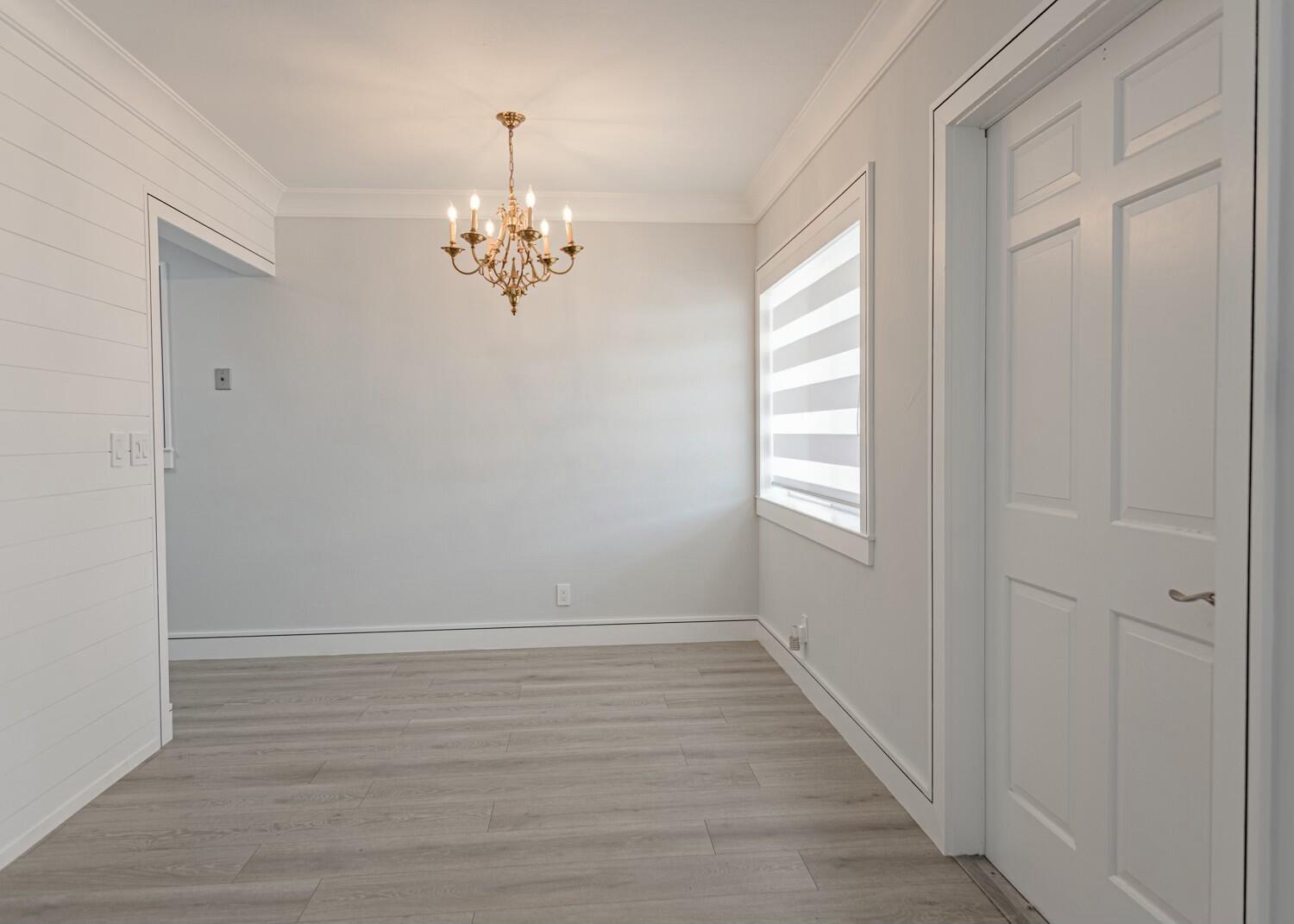 An empty dining room with light wood floors, white shiplap walls, and a brass chandelier — 2840 Cynthia 204 Lane # 204, FL 33461, FL