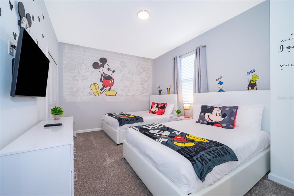 A bedroom features two beds with Mickey Mouse bedding and a large Mickey Mouse wall mural — 9335 SOMMERSET HILLS DRIVE UNIT 9335, DAVENPORT, FL