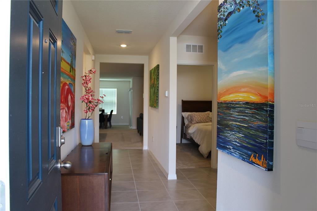 A view from an entryway looking down a tiled hallway toward a dining area — 2917 CANARY LANE, TAVARES, FL