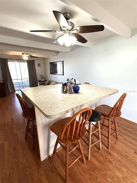 A kitchen island with bar stools sits under a ceiling fan in an open room — 3013 CLUB CIRCLE, LAKESHORE, FL