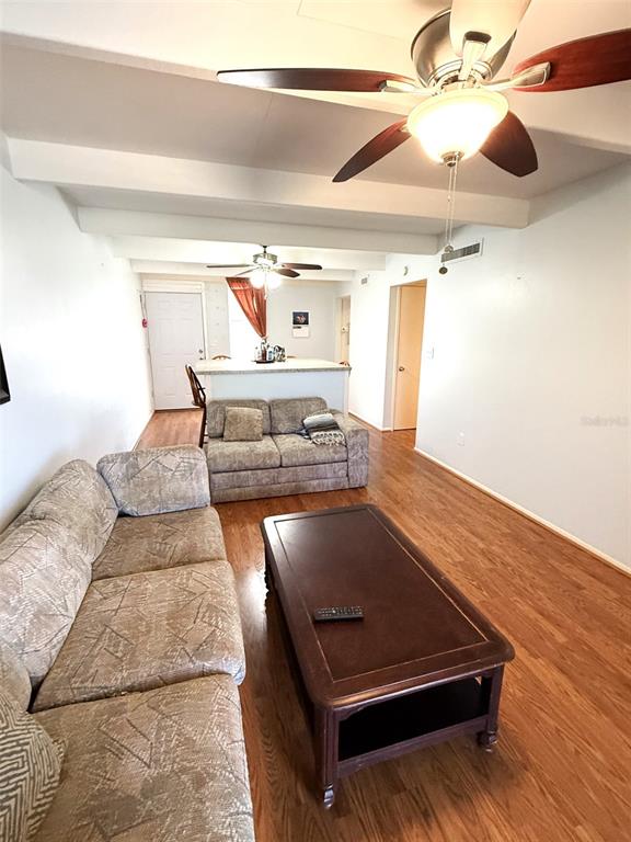 A living room features a beige sofa, a dark wood coffee table, and a ceiling fan — 3013 CLUB CIRCLE, LAKESHORE, FL