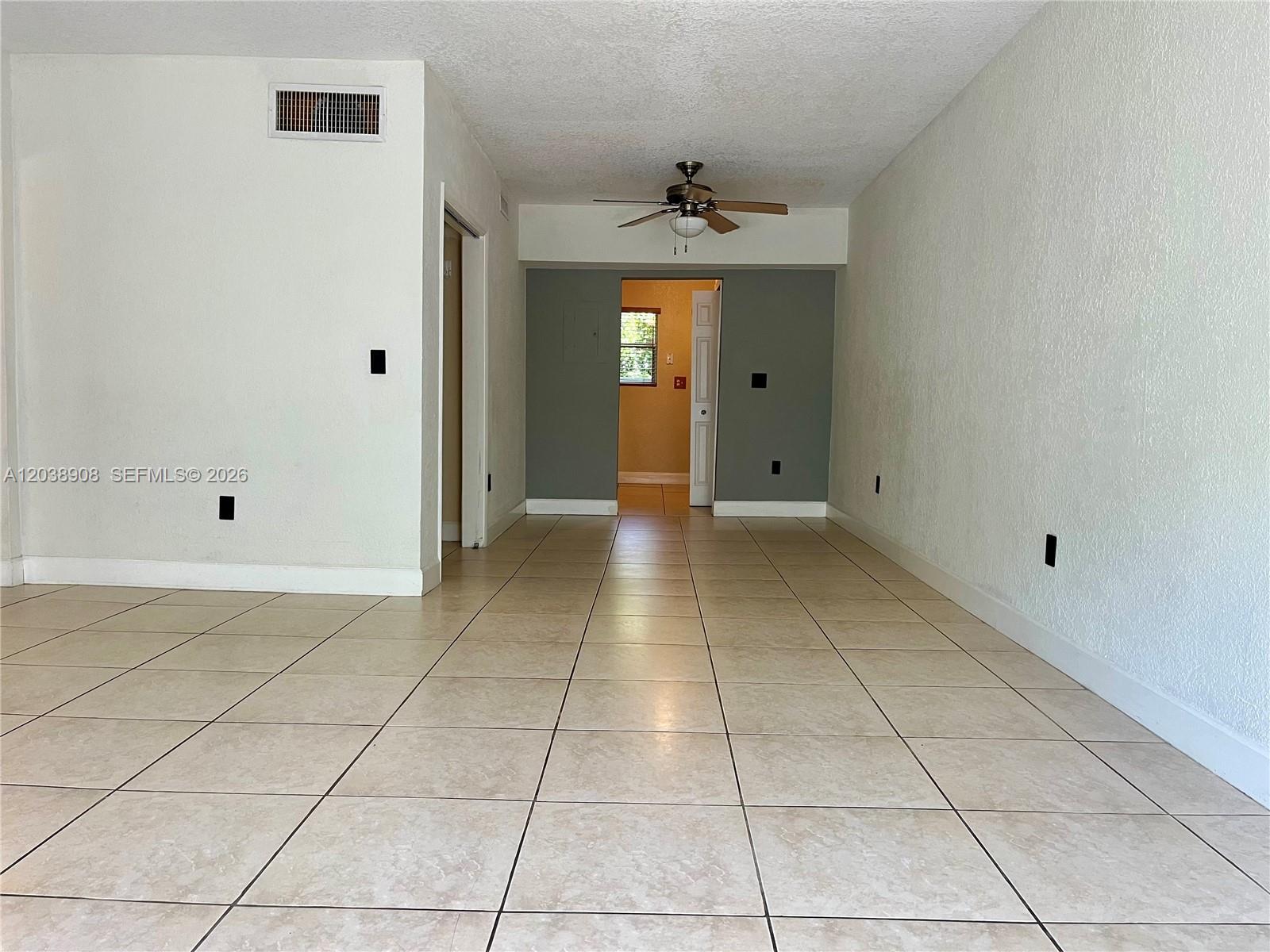 An empty room features beige tile flooring, white walls, and a ceiling fan — 1150 99th St # 6, Bay Harbor Islands FL 33154, BAY HARBOR ISLANDS, FL