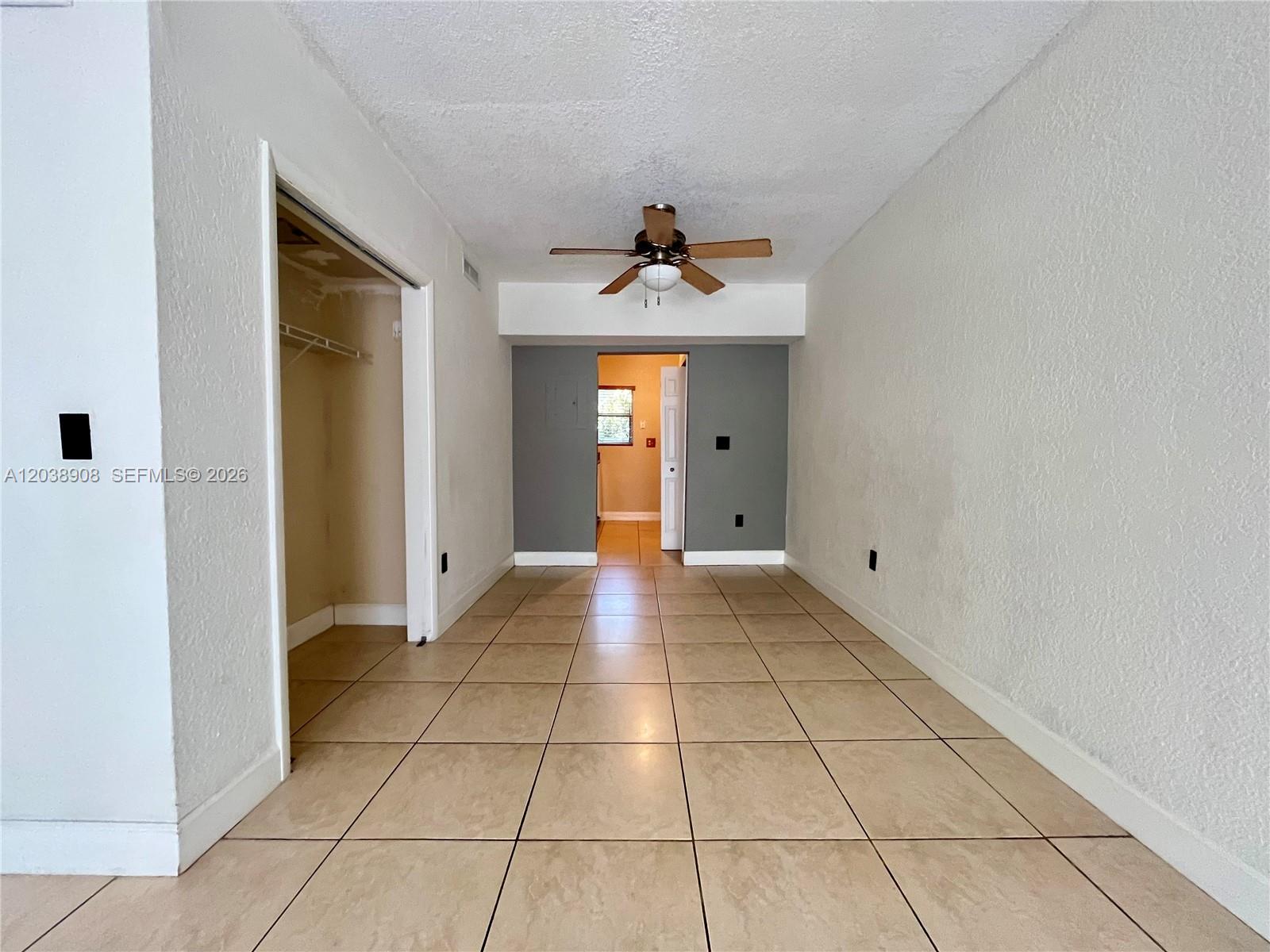 A room with beige tile flooring, white walls, a ceiling fan, and an open closet — 1150 99th St # 6, Bay Harbor Islands FL 33154, BAY HARBOR ISLANDS, FL