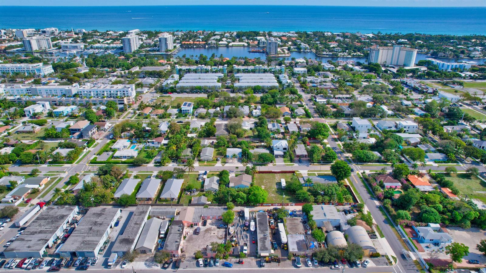 Aerial view of a coastal neighborhood featuring residential homes, commercial buildings, and a distant ocean — 369 SE 2nd Avenue, Delray Beach FL 33483, DELRAY BEACH, FL