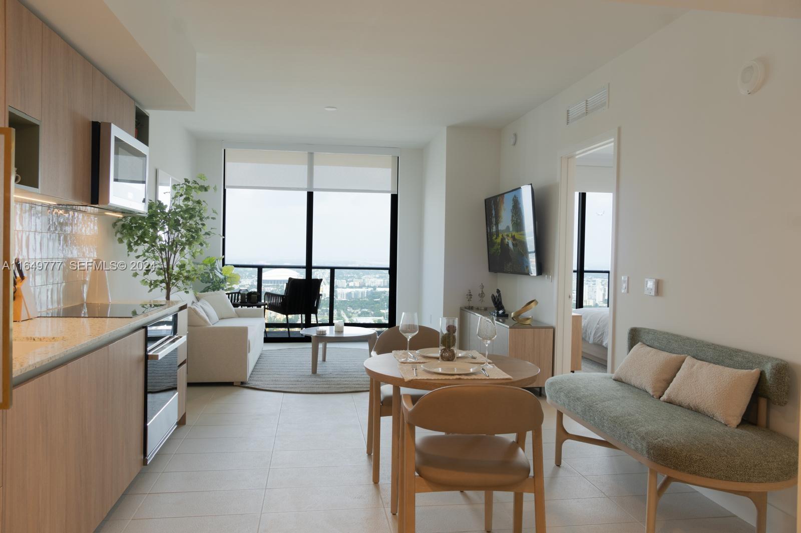 This modern apartment features an open-plan kitchen, dining area, and living room with balcony access — 601 NE 1 Ave # 4704, Miami FL 33132, MIAMI, FL