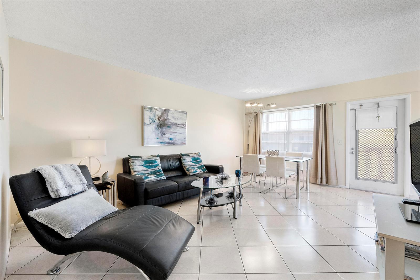 A living and dining area features black leather furniture, a glass coffee table, and tile floors — 281 Fanshaw G, Boca Raton FL 33434, BOCA RATON, FL
