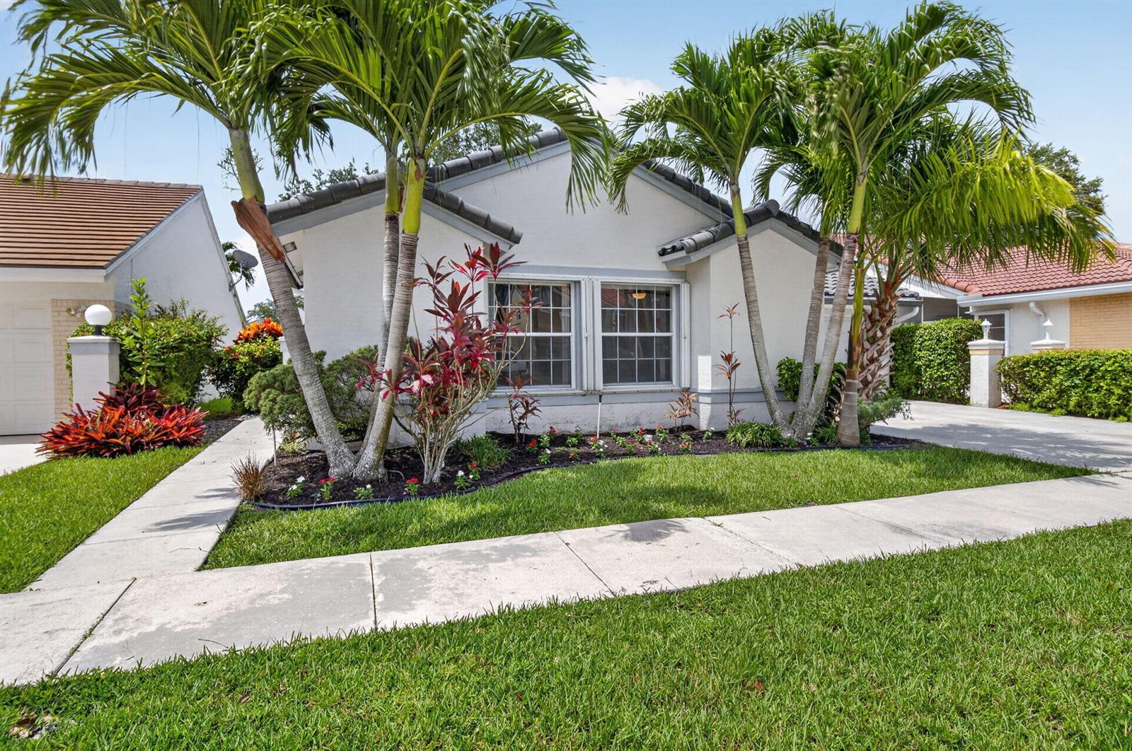 A single-story house with a white exterior, palm trees, and a landscaped front yard — 10048 Country Brook Road, Boca Raton FL 33428, BOCA RATON, FL
