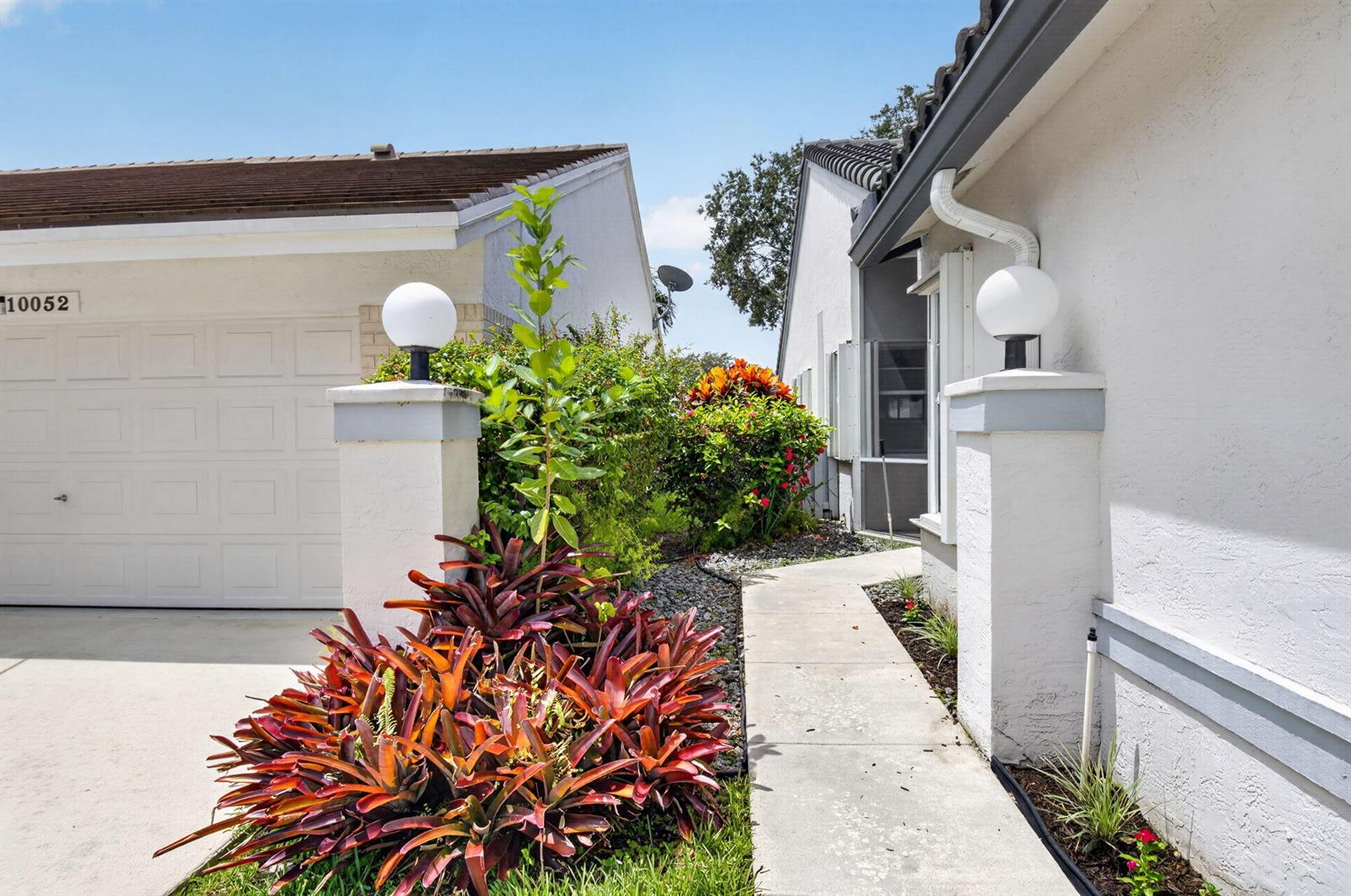 A concrete walkway leads between two white stucco houses with globe-style pillar lights — 10048 Country Brook Road, Boca Raton FL 33428, BOCA RATON, FL