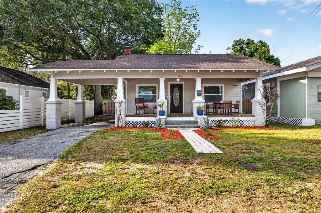 A single-story house with a front porch, carport, and a paved walkway on the lawn — 307 W CHELSEA STREET, TAMPA, FL