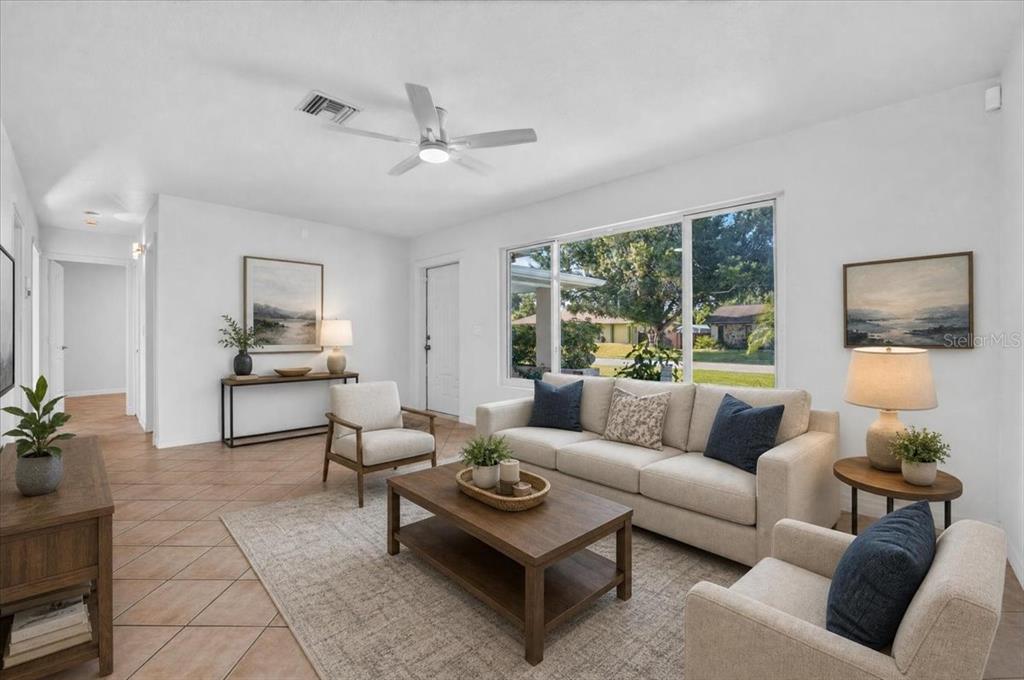 A living room features a beige sofa, two armchairs, a coffee table, and tile flooring — 20286 BENTON AVENUE, PORT CHARLOTTE, FL