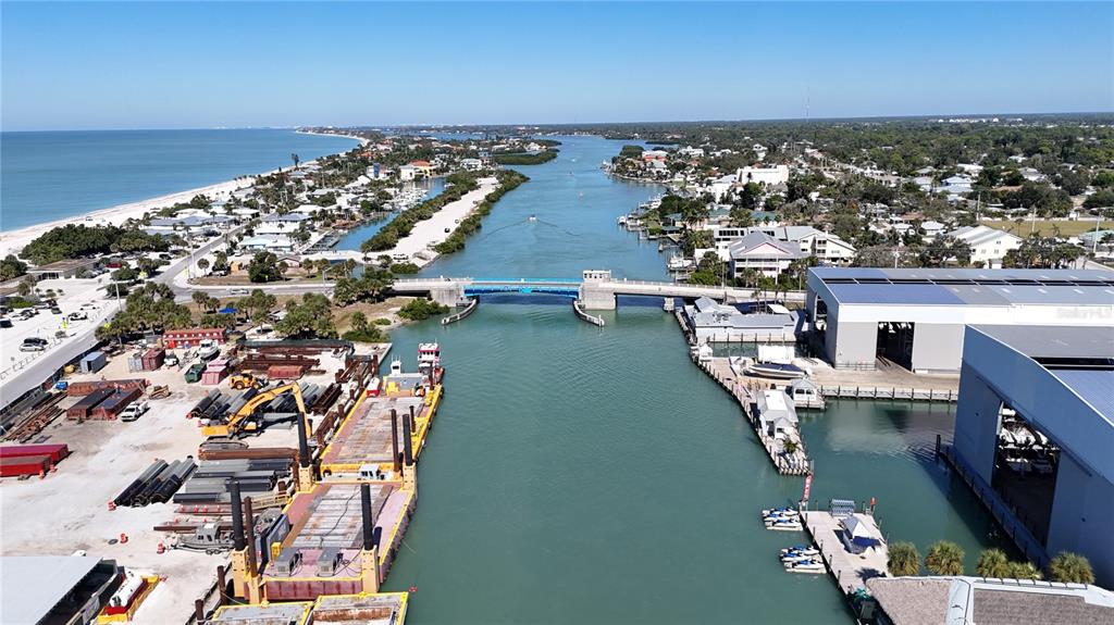An aerial view shows a waterway with a drawbridge, industrial barges, and surrounding coastal buildings — 100 CIRCUIT ROAD UNIT N93, NOKOMIS, FL