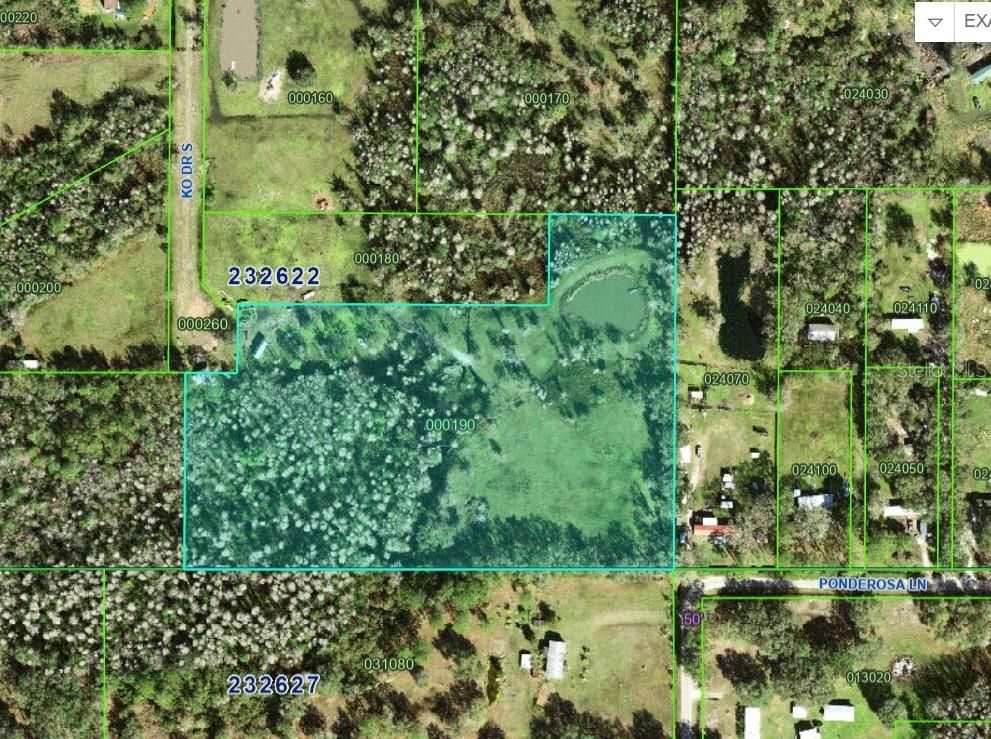An aerial view shows a large, grassy rural lot with trees, a pond, and outbuildings — 11111 KO DRIVE, LAKELAND, FL