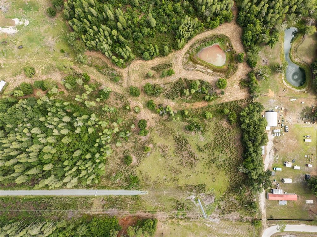 An aerial view shows a rural property with a pond, wooded areas, and several outbuildings — 11111 KO DRIVE, LAKELAND, FL