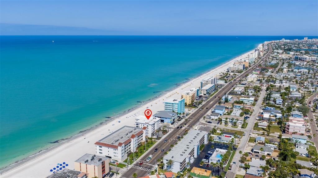 An aerial view shows a beachfront apartment building with a red location marker — 14048 GULF BOULEVARD UNIT 201, MADEIRA BEACH, FL