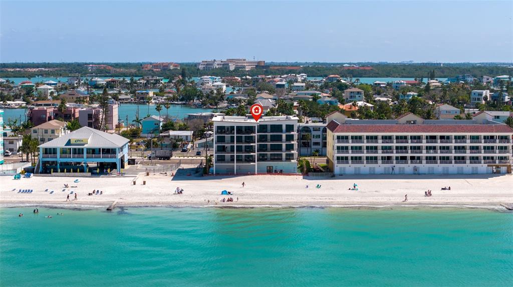 An aerial view of a multi-story beachfront building with a red location marker — 14048 GULF BOULEVARD UNIT 201, MADEIRA BEACH, FL