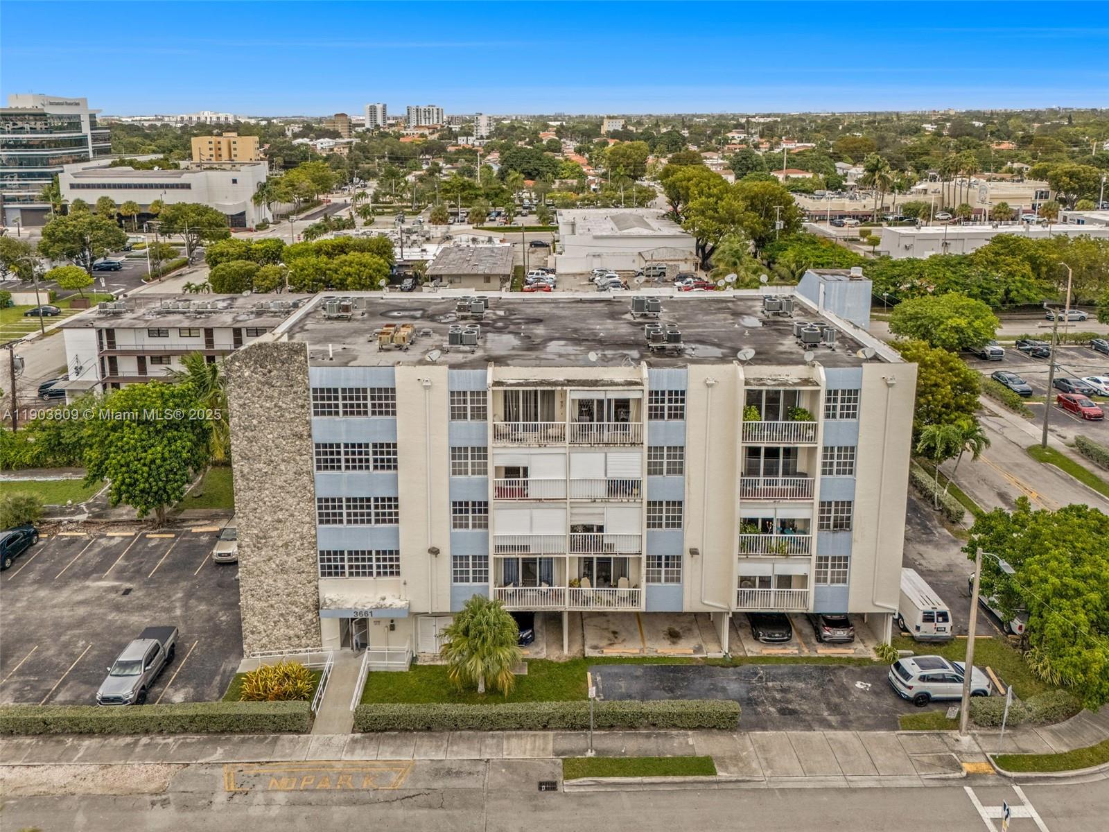 An aerial view shows a four-story apartment building with a parking lot and surrounding neighborhood — 3661 SW 9th Ter # 207, Miami FL 33135, MIAMI, FL
