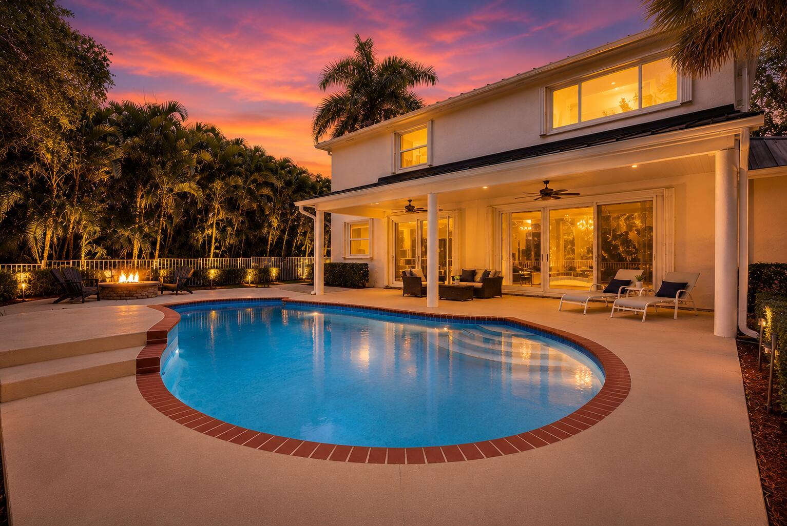 A two-story house with a pool, patio, fire pit, and sunset sky in the background — 6020 NW 104th Lane, Parkland FL 33076, PARKLAND, FL
