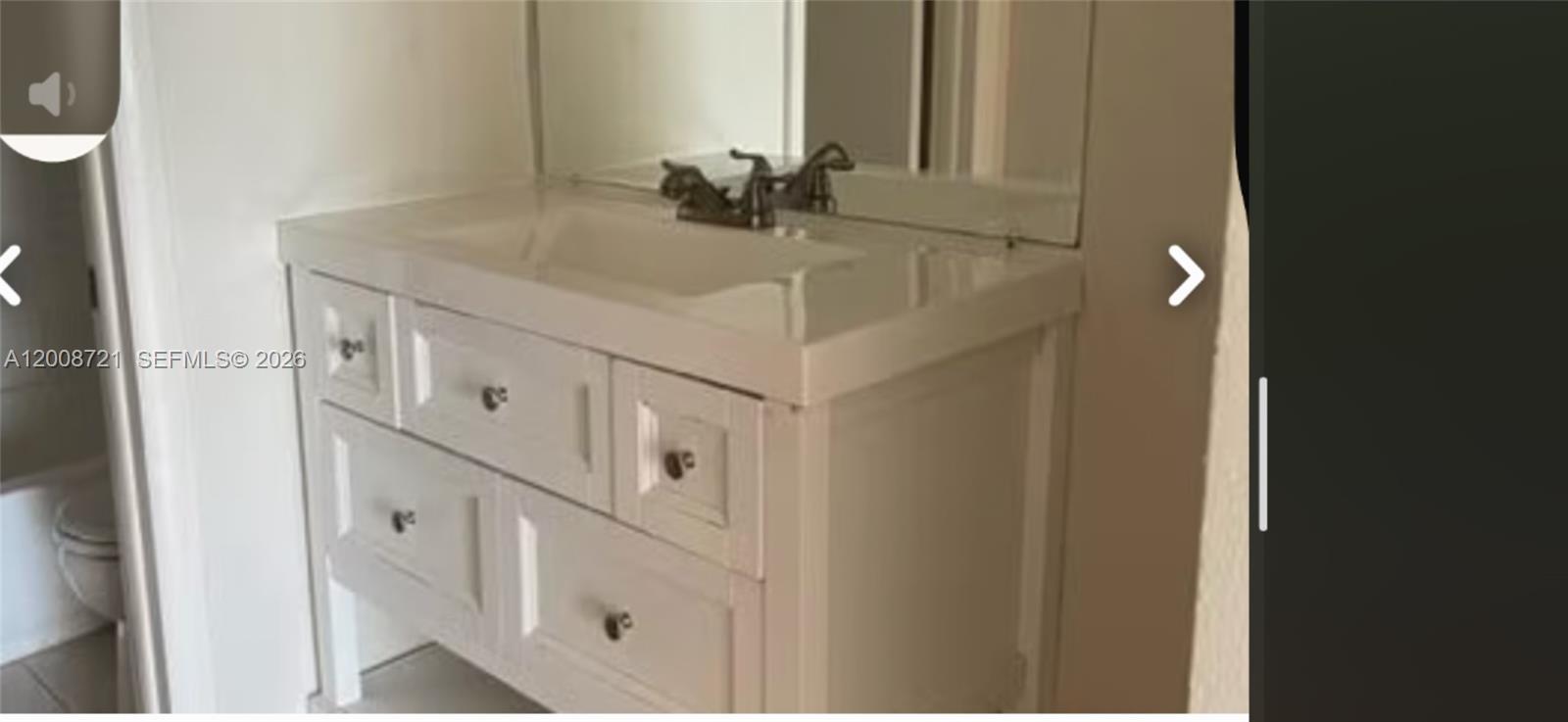 A white bathroom vanity with a sink, faucet, and mirror stands against a wall — 2600 Fiore Way # B, Delray Beach FL 33445, DELRAY BEACH, FL