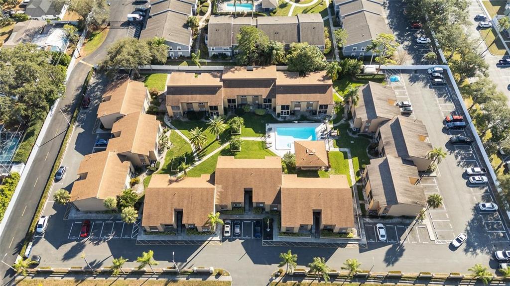 An aerial view of a multi-building apartment complex featuring a central swimming pool and parking — 1589 GREENLEA DRIVE UNIT 3, CLEARWATER, FL