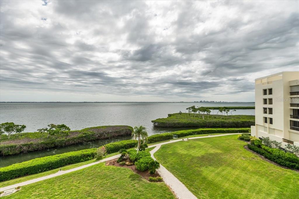 An elevated view of a grassy lawn, a winding path, mangroves, and a large bay — 2020 HARBOURSIDE DRIVE UNIT 446, LONGBOAT KEY, FL