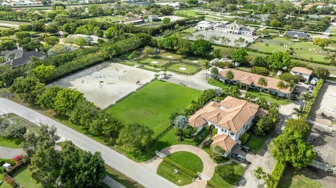 An aerial view shows a residential property with a large riding arena and stables — 14471 Equestrian Way, Wellington FL 33414, WELLINGTON, FL