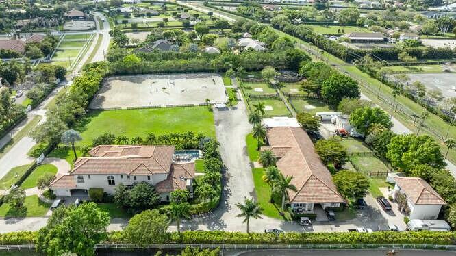 An aerial view of a residential equestrian property featuring a house, stables, and riding arena — 14471 Equestrian Way, Wellington FL 33414, WELLINGTON, FL