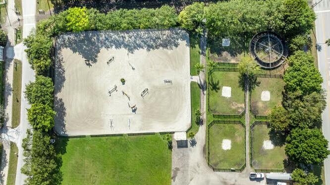 An aerial view shows a horse riding arena, four fenced paddocks, and a round pen — 14471 Equestrian Way, Wellington FL 33414, WELLINGTON, FL