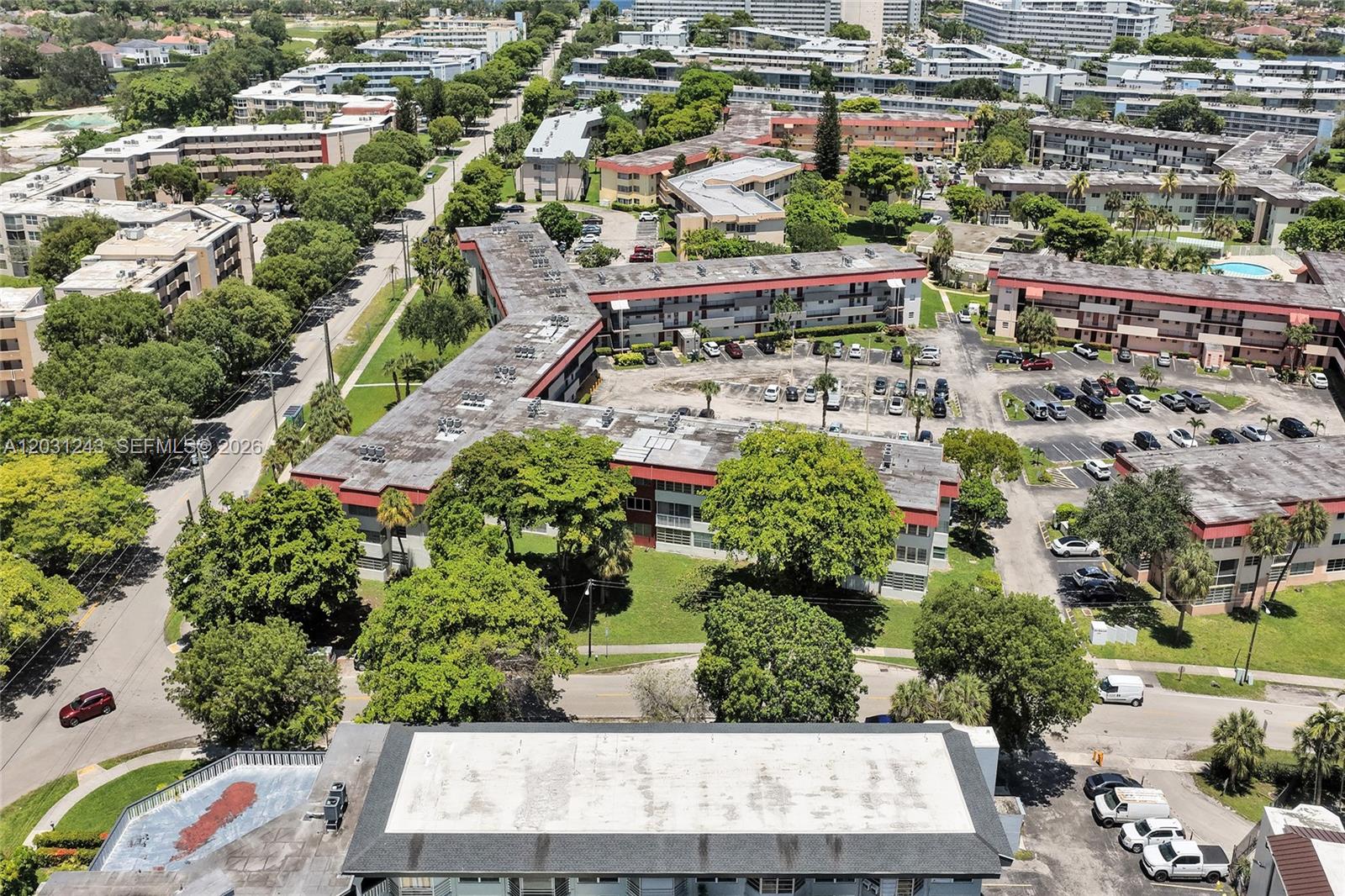 An aerial view shows multi-story apartment buildings with flat roofs and surrounding parking lots — 1400 NE 191st St # 343, Miami FL 33179, MIAMI, FL