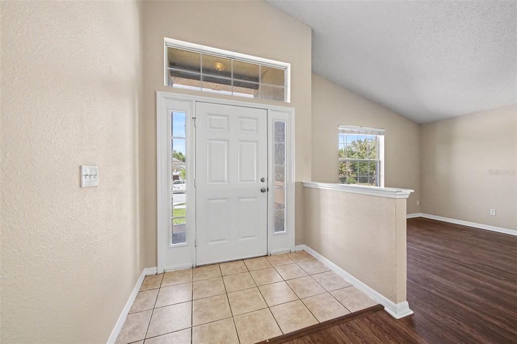 An entryway with a tiled floor, a white front door, and a partial wall divider — 1110 BLUEGRASS DRIVE, GROVELAND, FL