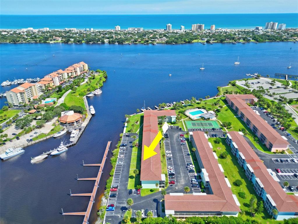 An aerial view shows a multi-story apartment building with a yellow arrow pointing toward it — 715 S BEACH STREET UNIT 314D, DAYTONA BEACH, FL