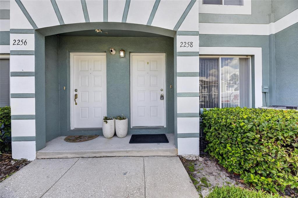 The exterior view shows two white front doors with address numbers on a stucco building — 2258 FLUORSHIRE DRIVE, BRANDON, FL