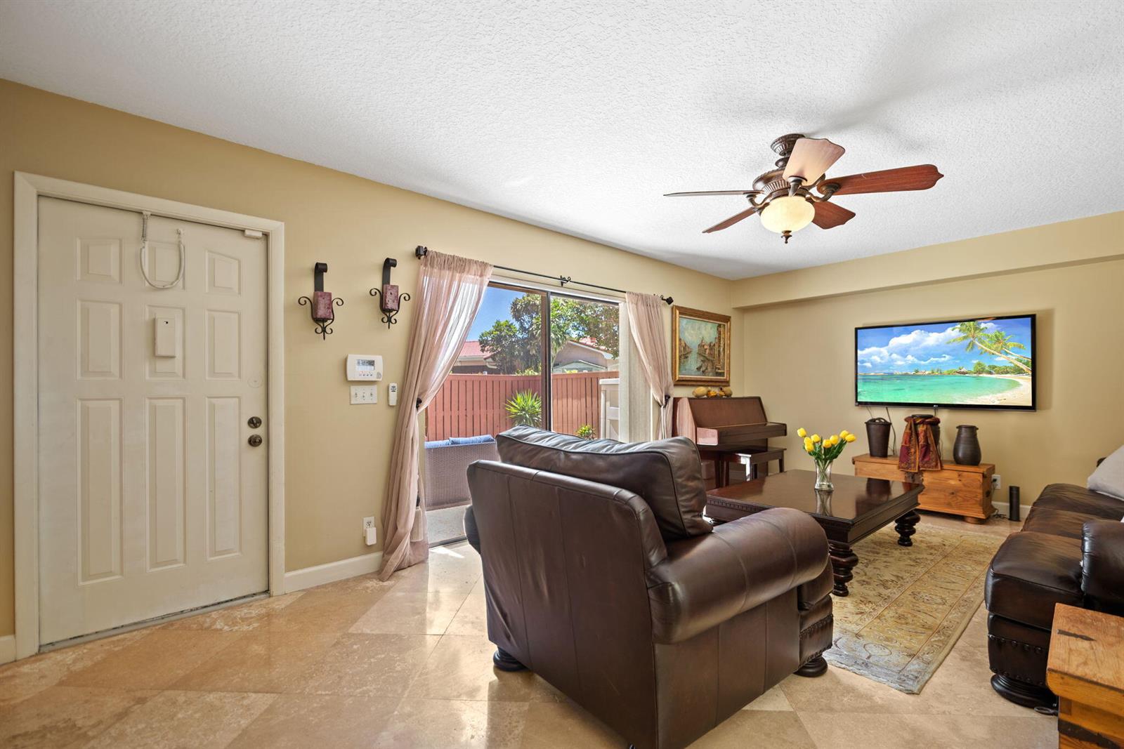 A living room features tile floors, a leather armchair, a sofa, and a sliding glass door — 2874 Waterford Drive S, Deerfield Beach FL 33442, DEERFIELD BEACH, FL