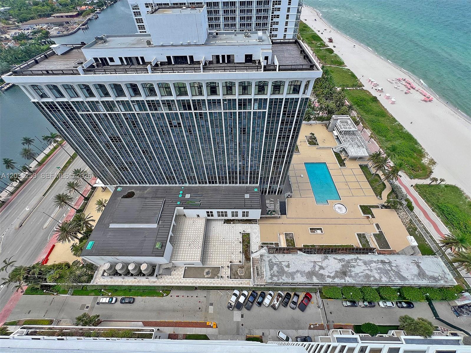 An aerial view shows a high-rise building with a pool deck, parking, and beach access — 4779 Collins Ave # 2708, Miami Beach FL 33140, MIAMI BEACH, FL