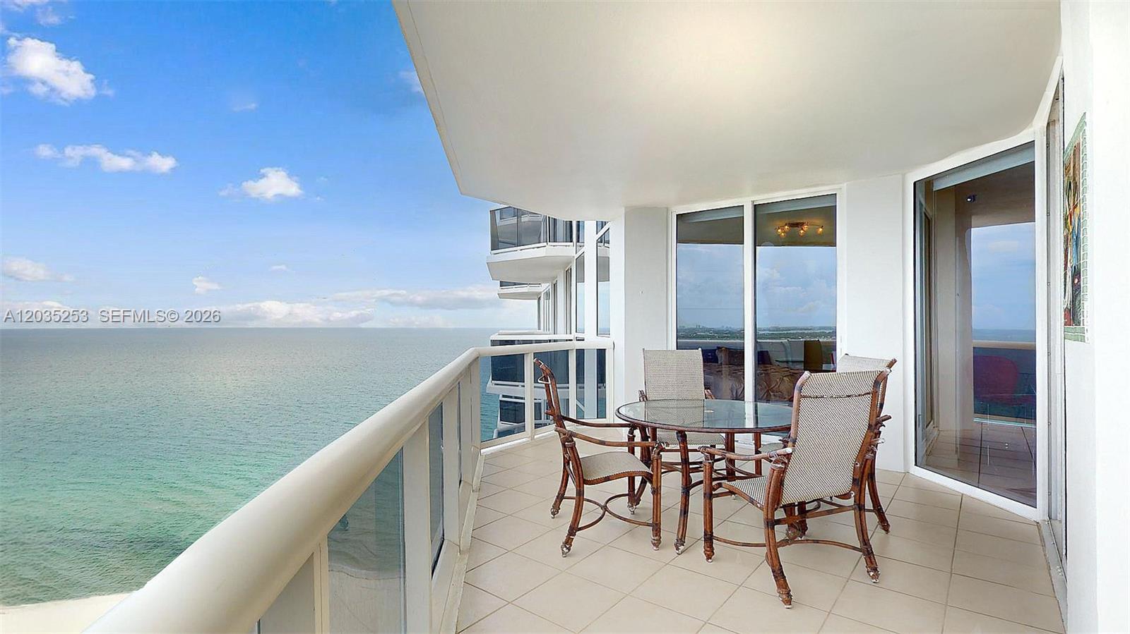 A balcony with a glass railing overlooks the ocean and features a patio dining set — 4779 Collins Ave # 2708, Miami Beach FL 33140, MIAMI BEACH, FL