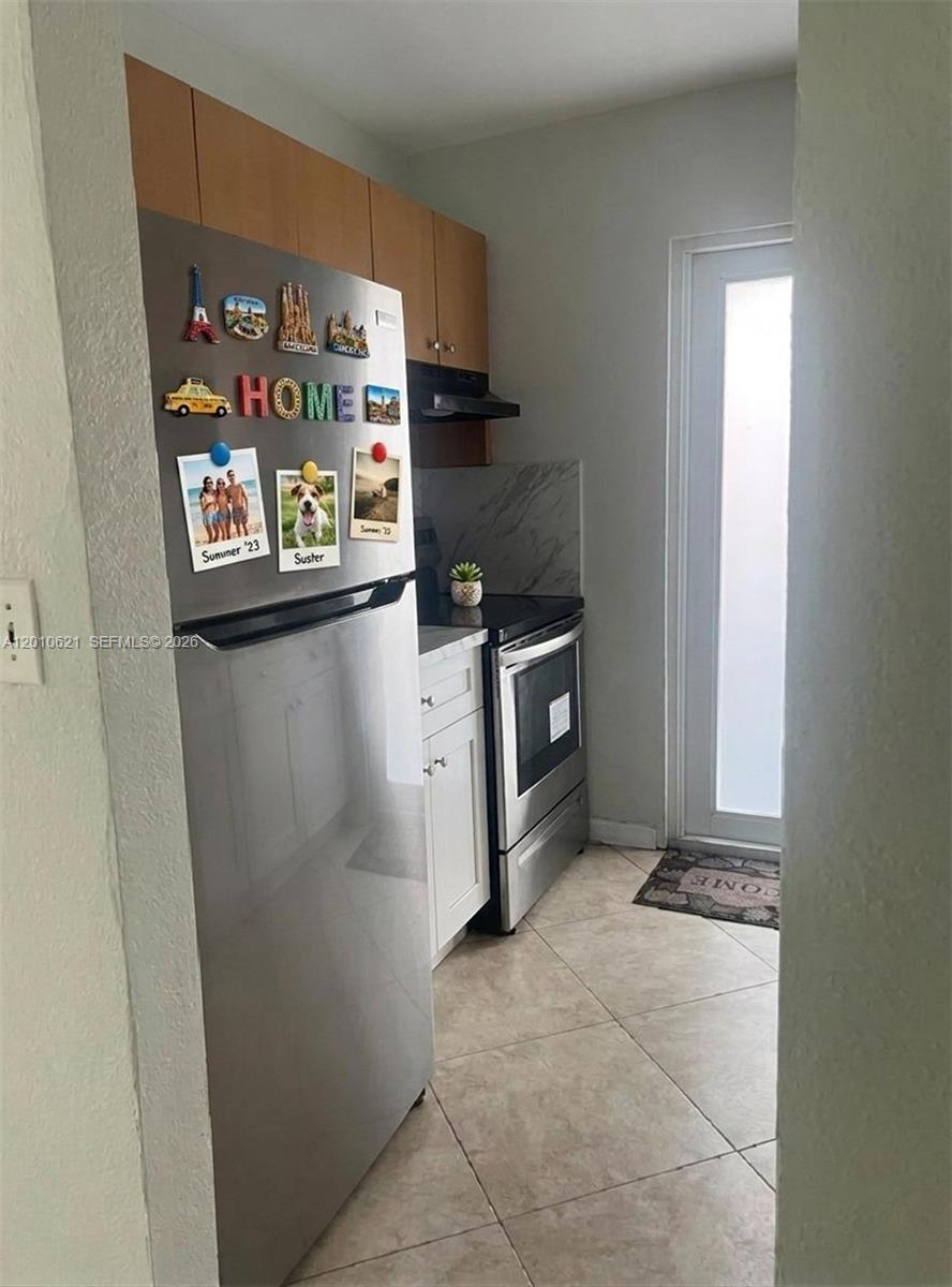 A small kitchen features stainless steel appliances, light wood cabinets, and white lower cabinetry — 2412 SW 11th St # 1, Miami FL 33135, MIAMI, FL