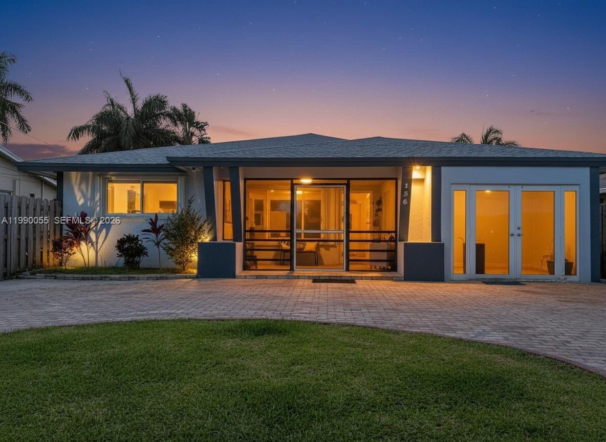 A single-story house with a paved driveway, screened front porch, and glass double doors — 136 SE 2nd Ct, Dania Beach FL 33004, DANIA BEACH, FL