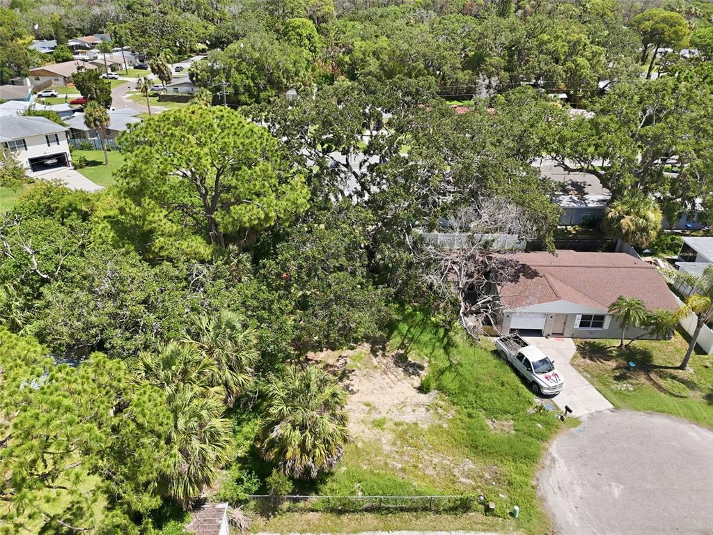 An aerial view shows a vacant lot next to a house with a white truck — 4925 AMHERST COURT, NEW PORT RICHEY, FL