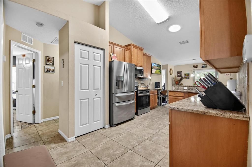 A kitchen with granite countertops, stainless steel appliances, and light-colored tile flooring — 203 FRONTIER DRIVE, PALM COAST, FL