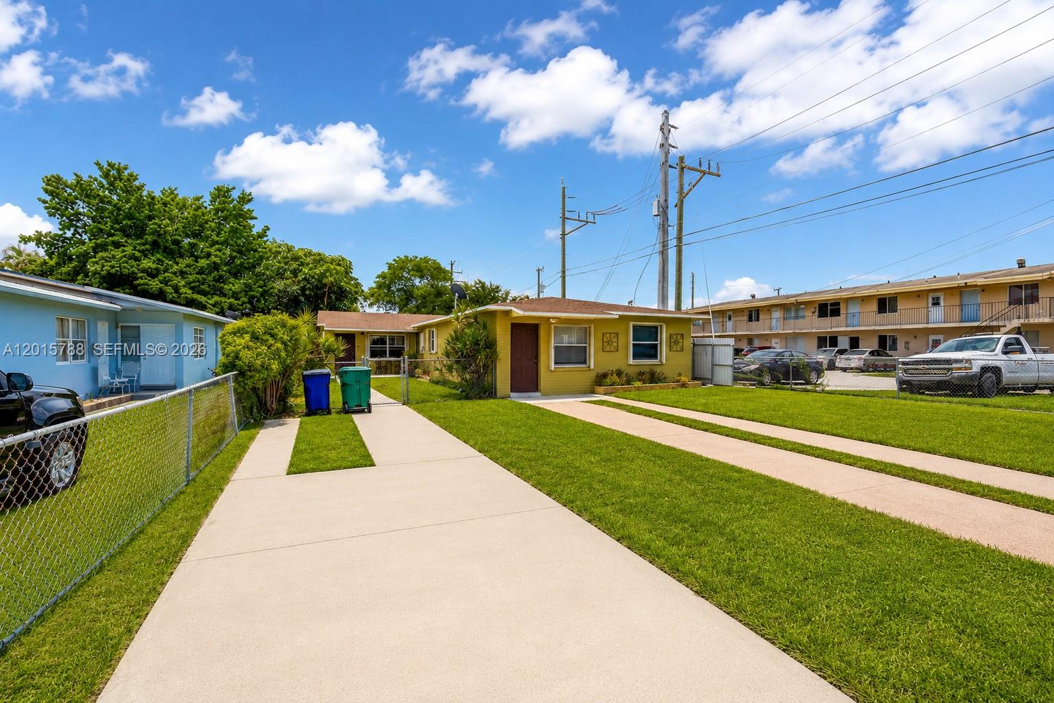 A yellow single-story house with a concrete driveway and a chain-link fence — 7358 - 7360 SW 23rd St, Miami FL 33155, MIAMI, FL