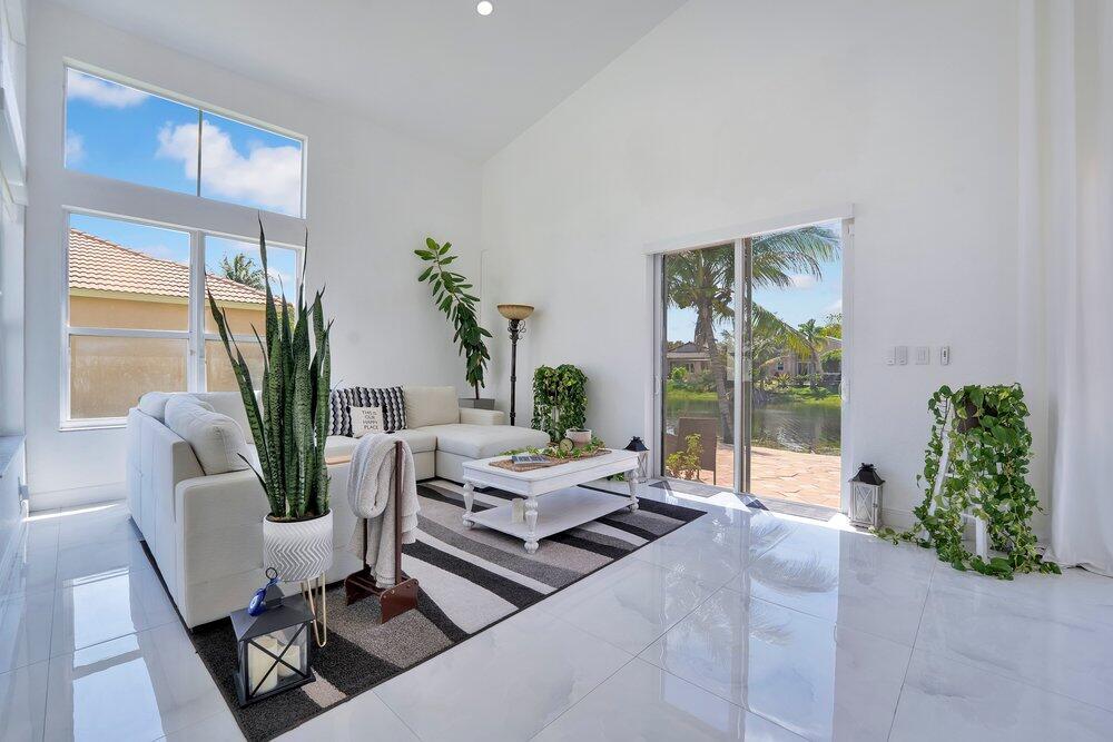 A bright living room features white tile floors, a sectional sofa, and large sliding doors — 2242 SW 130th Terrace, Miramar FL 33027, MIRAMAR, FL