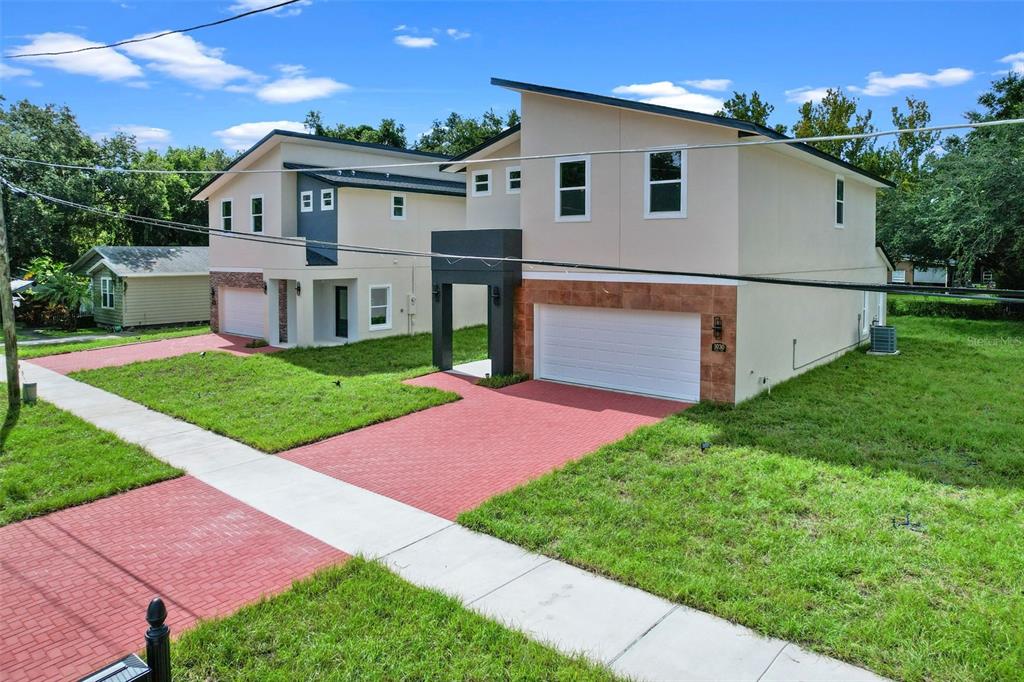 Two modern two-story houses with white stucco exteriors and red brick driveways stand side-by-side — 1030 WILKS AVENUE, ORLANDO, FL