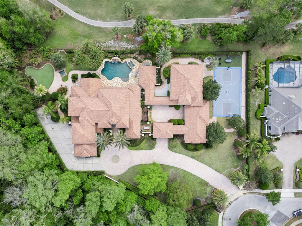 An aerial view shows a large house with a pool, basketball court, and putting green — 3545 LEGACY HILLS COURT, LONGWOOD, FL