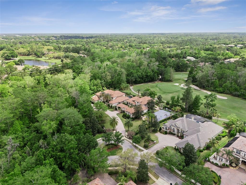 An aerial view shows two large houses situated next to a golf course and forest — 3545 LEGACY HILLS COURT, LONGWOOD, FL