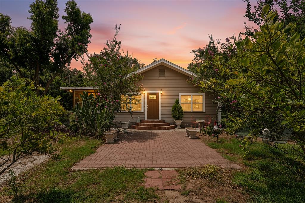 A single-story house with tan siding and a brick patio at sunset — 6202 STAFFORD ROAD, PLANT CITY, FL