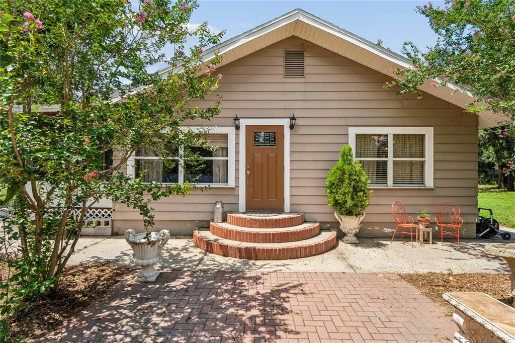 A tan house exterior features a brown front door, brick steps, and a brick patio — 6202 STAFFORD ROAD, PLANT CITY, FL